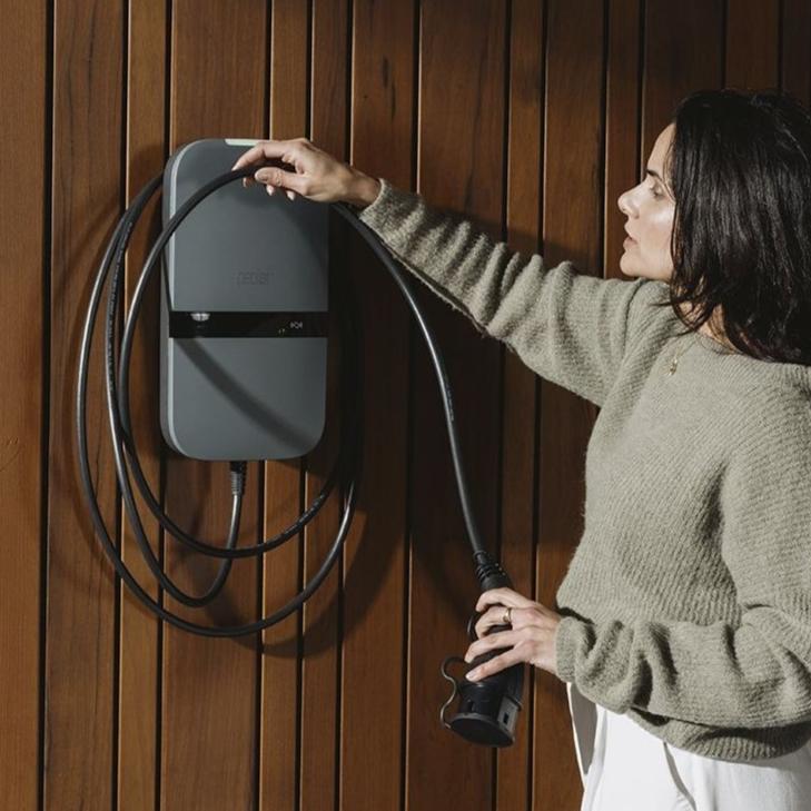 Vrouw pakt laadkabel van peblar laadpunt
